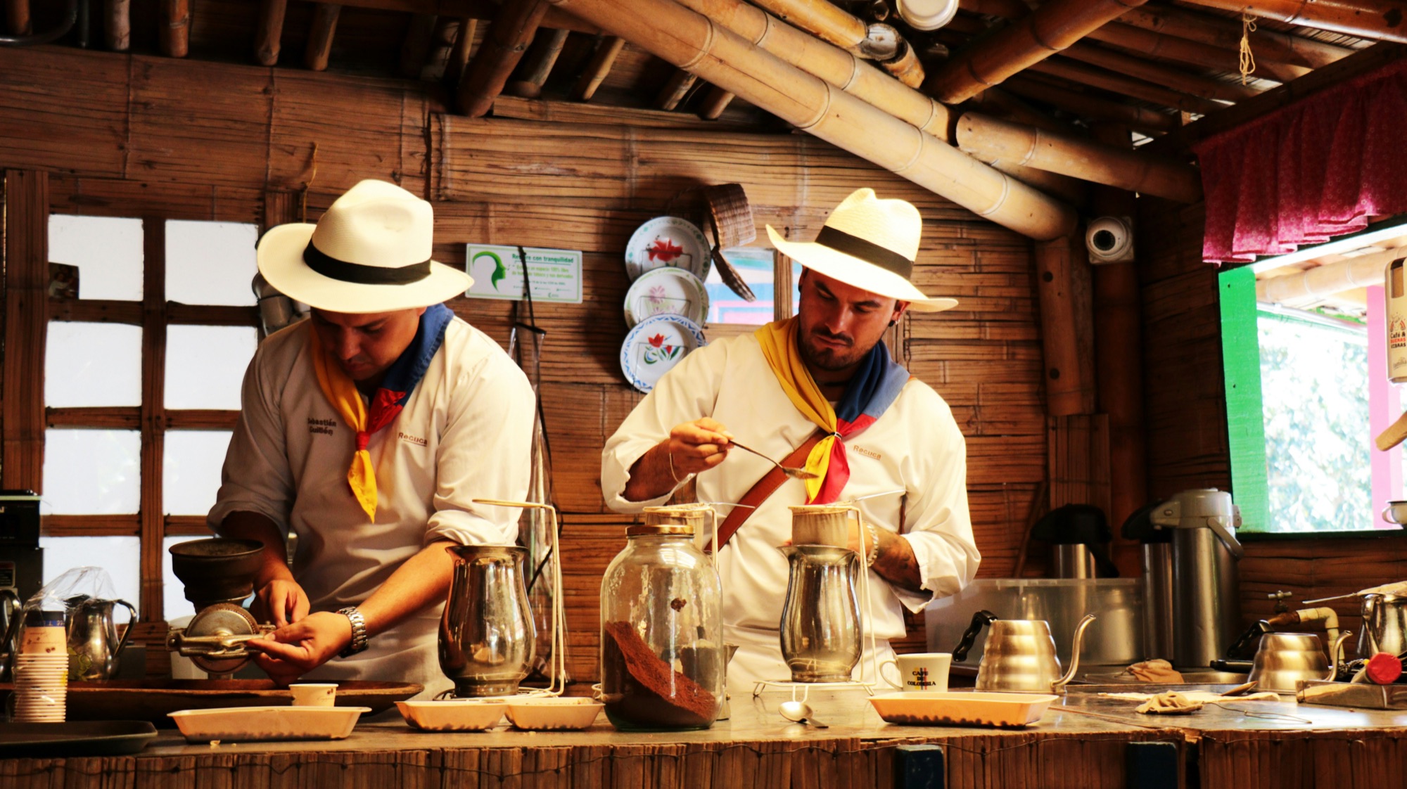 Dos baristas colombianos preparando café de origen en una cocina tradicional